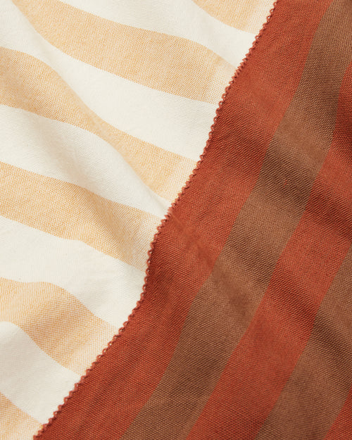close-up of striped cotton tablecloth ethically handwoven by MINNA in brown, cream, yellow, rust stripes.