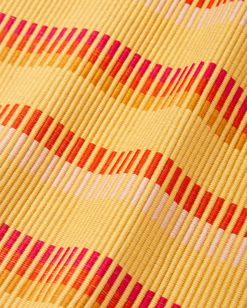 Close up detail of ethically handwoven MINNA cotton placemat in goldfinch, gold yellow, orange, fuschia