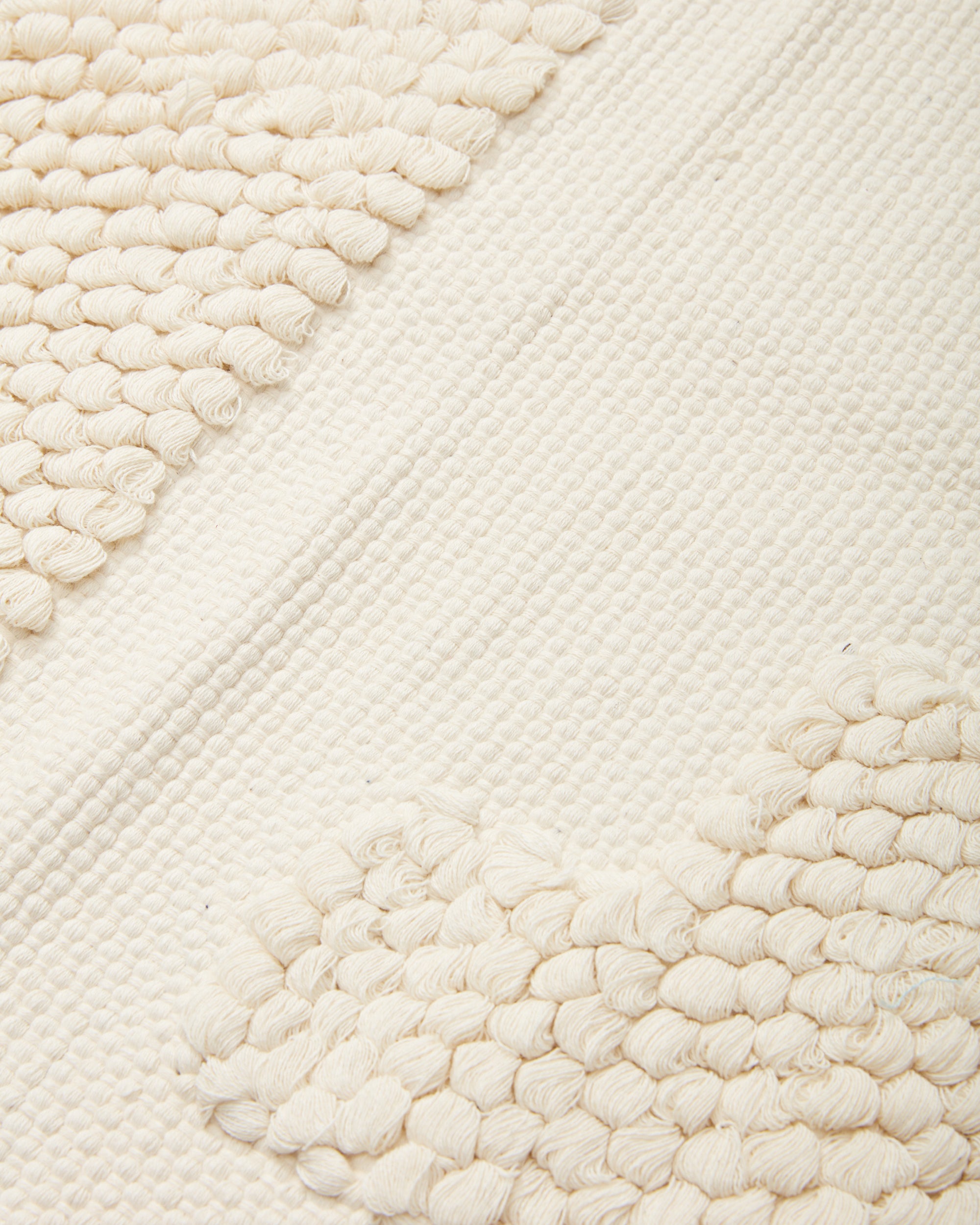 close-up detail of ethically handwoven organic cotton MINNA bathmat with textural pattern, cream, white
