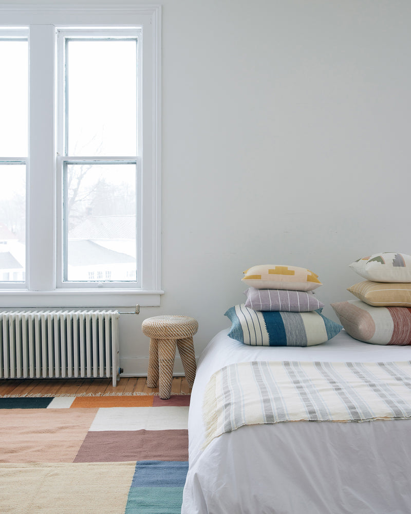 bright airy bedroom decor with ethically handwoven MINNA decorative throw pillows, blankets, and naturally dyed rug.