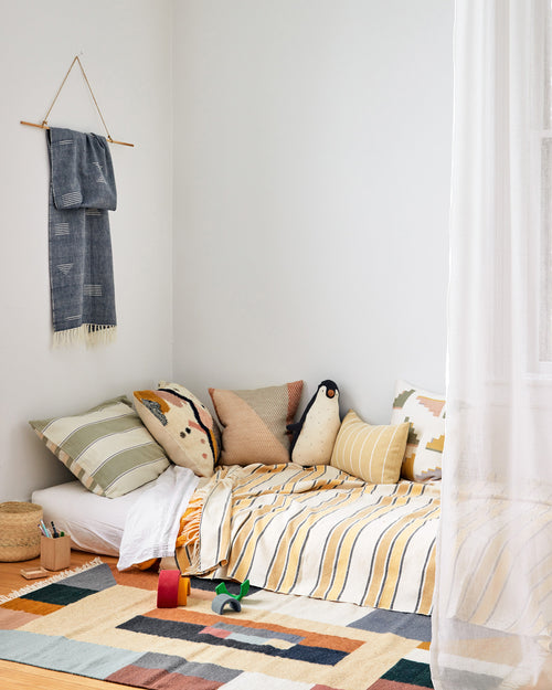 bedroom nook styled with ethically handwoven pillows throws and rugs