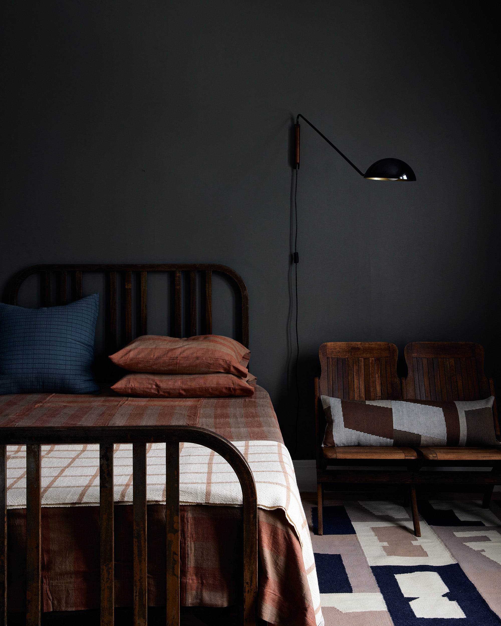 Dark bedroom decor with ethically handwoven bedding, blankets, and decorative throw pillows by MINNA