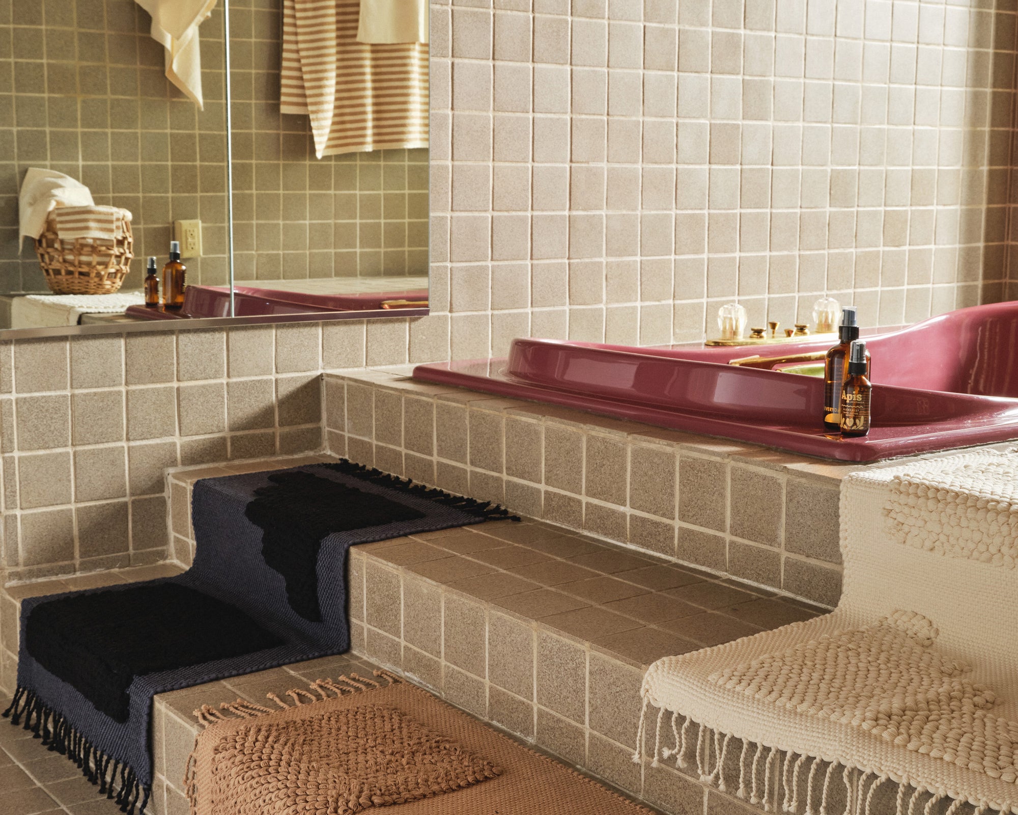 tiled bathroom with pink bathtub with handwoven organic cotton MINNA steps bath mats with minimal patterns indigo, beige, cream