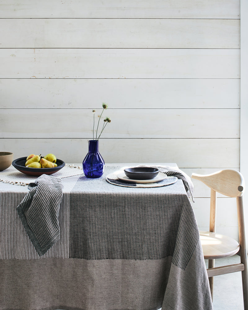 Minimal neutral table setting with MINNA ethically handmade handwoven tablecloth and npakins, beige, grey, white