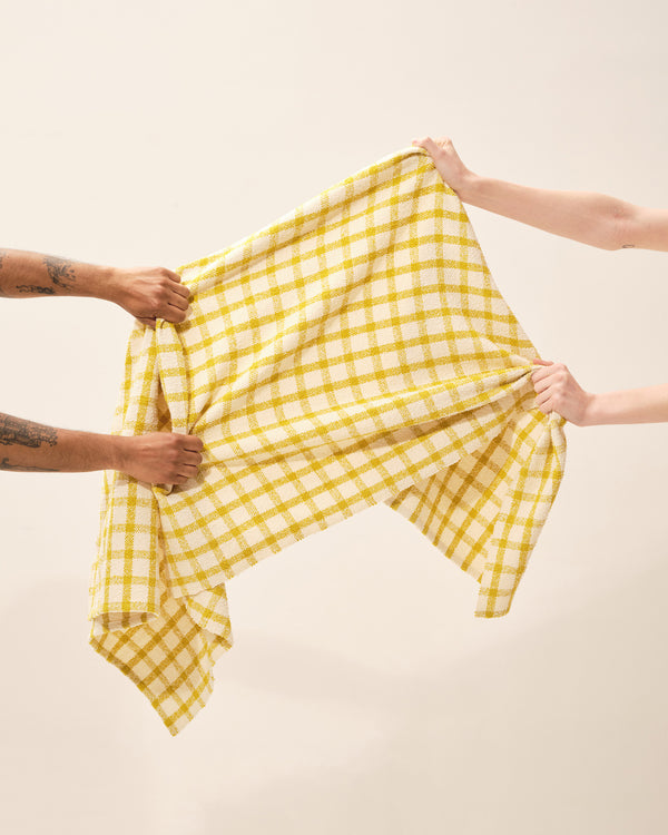 model with organic cotton boucle ethically made handwoven bath towel with yellow grid pattern