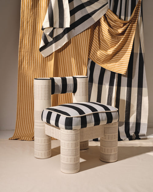The CRCL LikeMindedObjects x MINNA chair is ethically handwoven brightly colored striped black and white fabrics