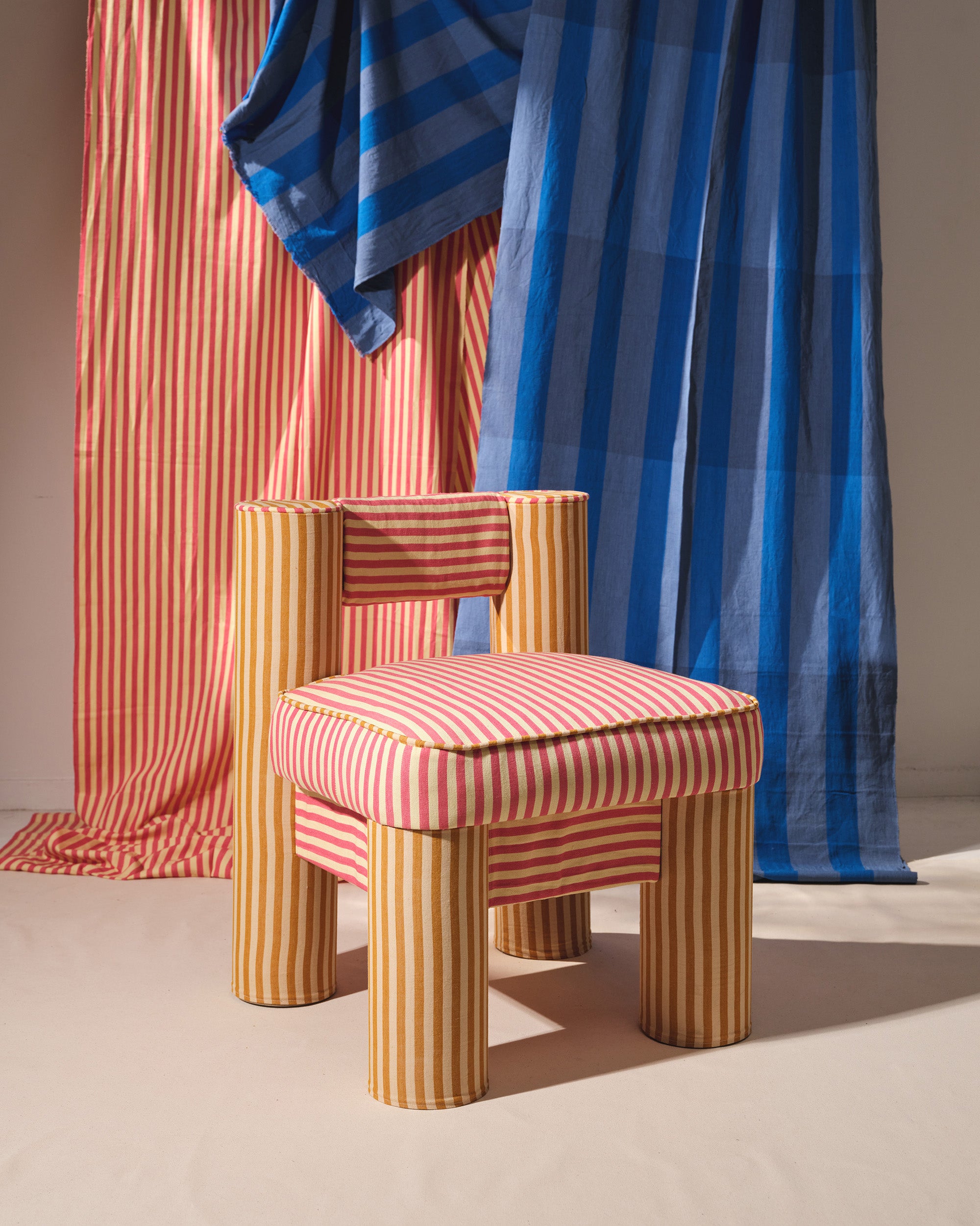 The CRCL LikeMindedObjects x MINNA chair is ethically handwoven brightly colored striped pink and golden yellow fabrics