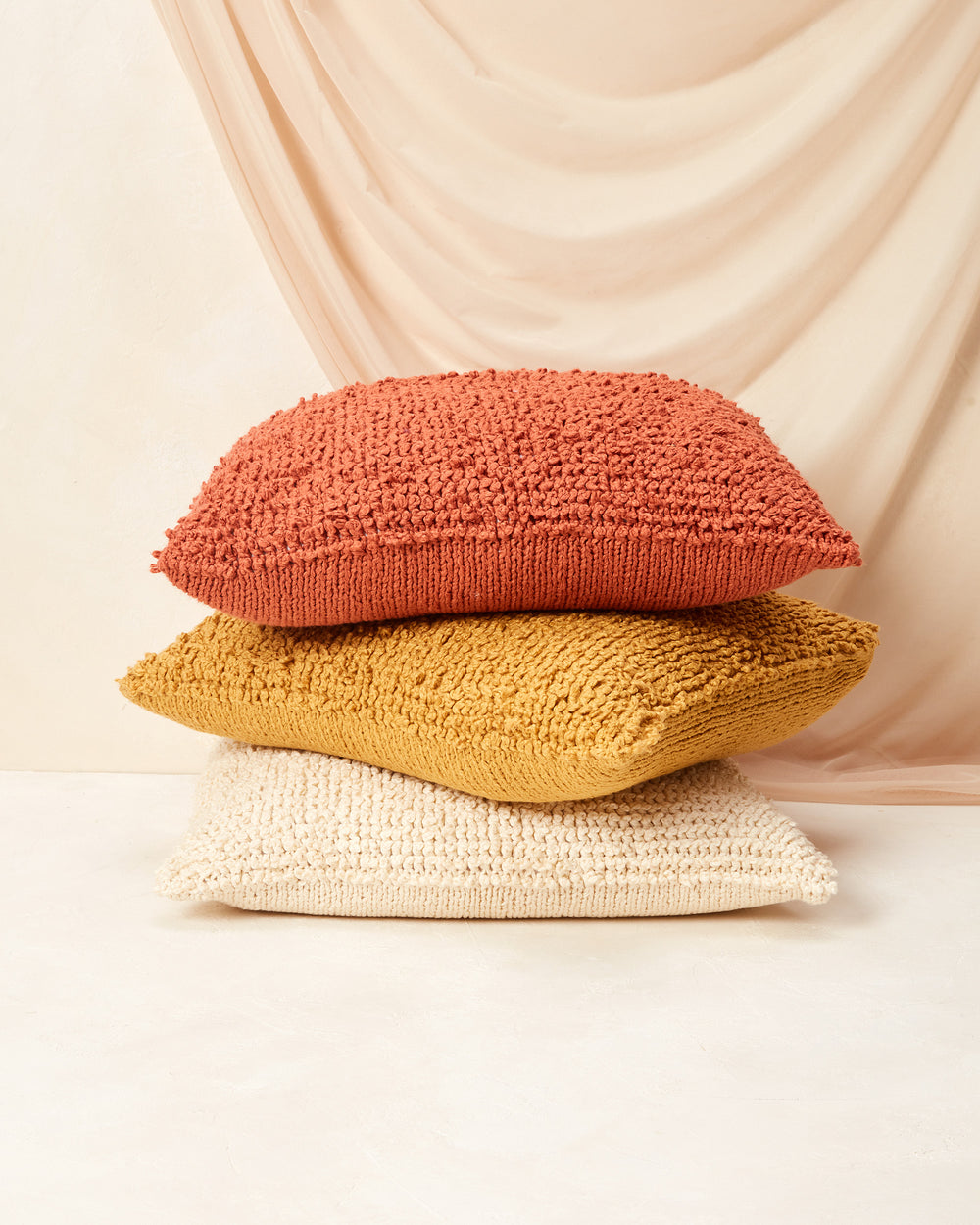Ethically made, hand knit MINNA Cloud Pillow in 100% GOTS-certified organic cotton in a cream, off-white, persimmon, coral, goldenrod, deep yellow.  Decorative Throw Pillow