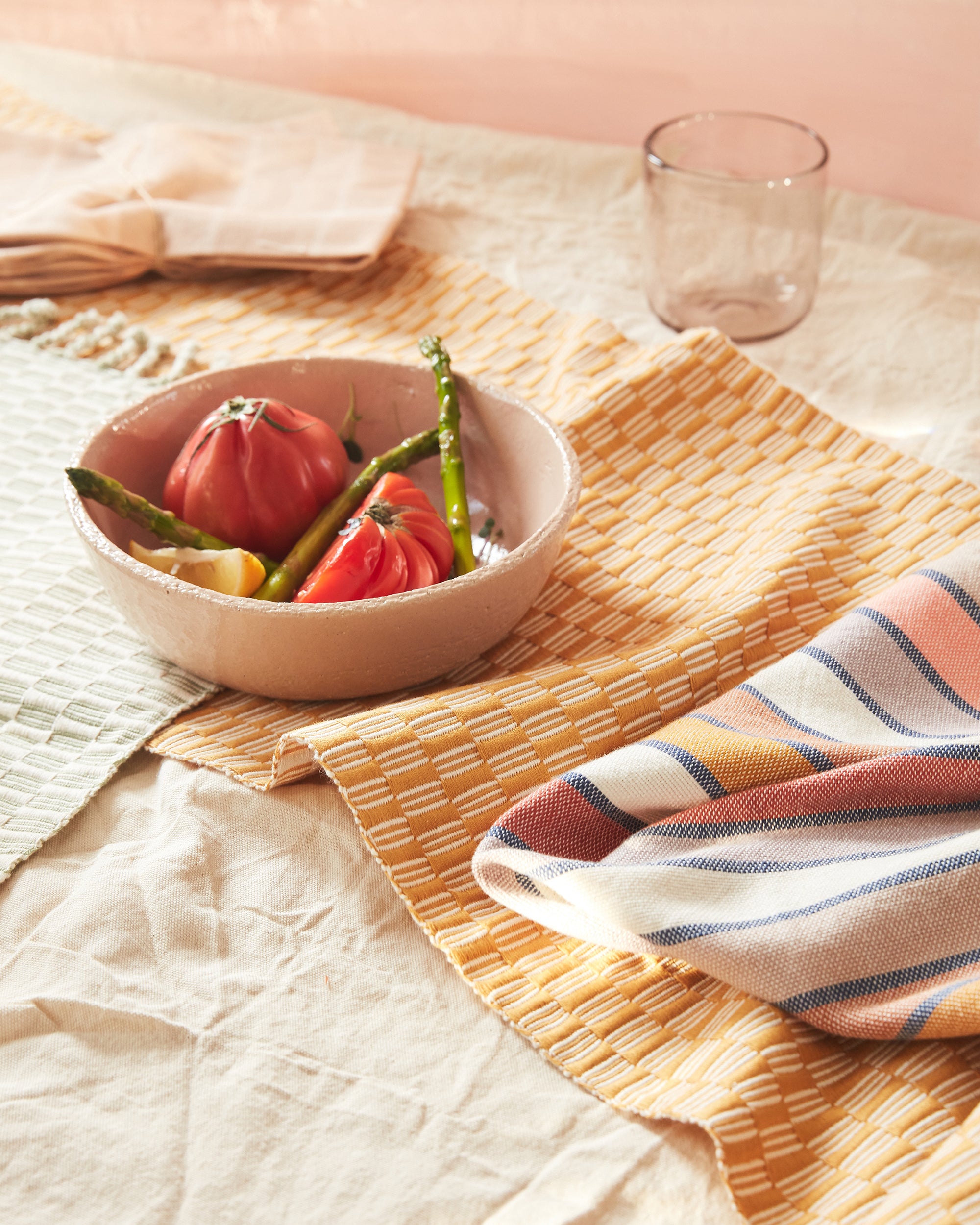 bright tabletop decor ethically handwoven MINNA panalito table runner in gold with striped napkin in gold, coral, rust, lavender color stripes