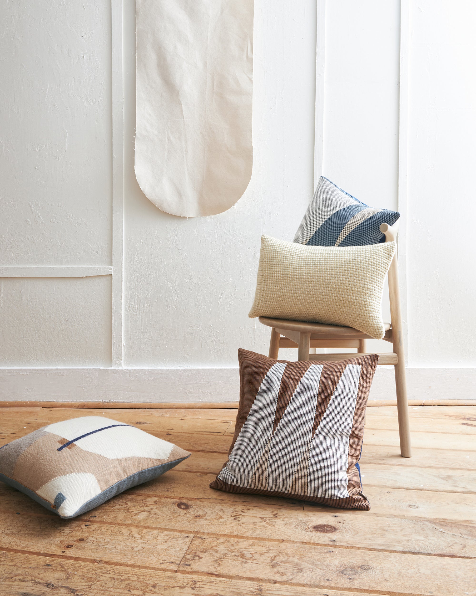 A minimal room with ethically handwoven decorative throw pillows designed by MINNA in cotton and alpaca.