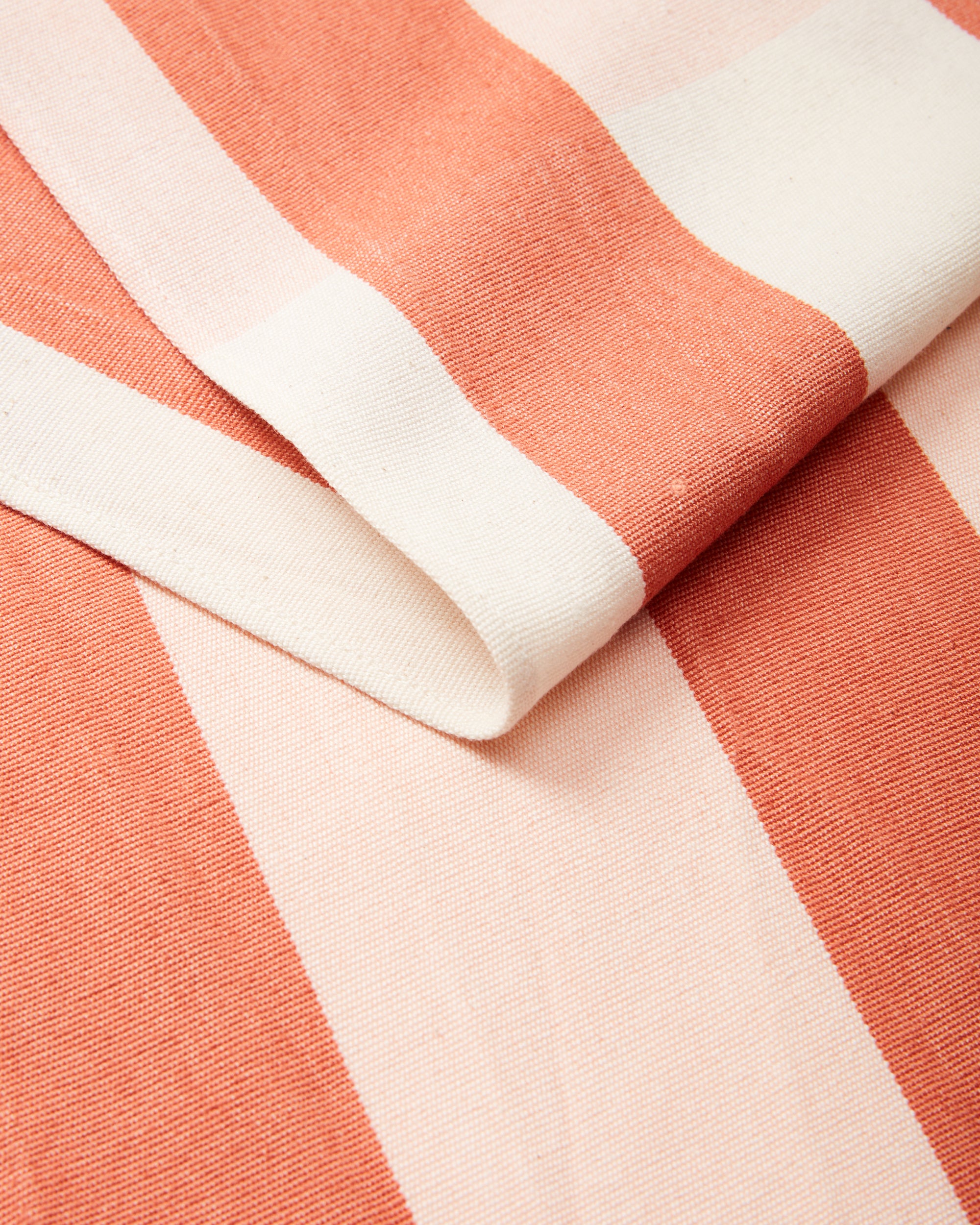 close-up detail ethically handwoven cotton table runner stripes coral peach