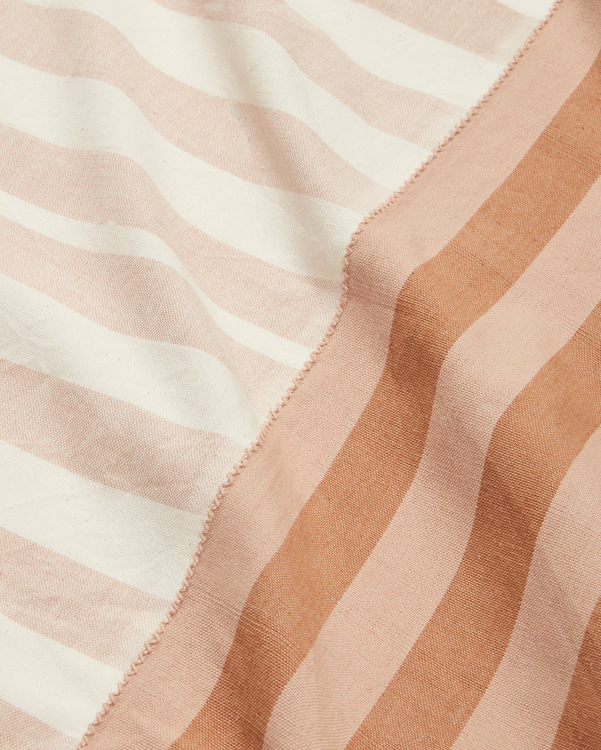 close-up of striped cotton tablecloth ethically handwoven by MINNA in neutral beige and light brown.