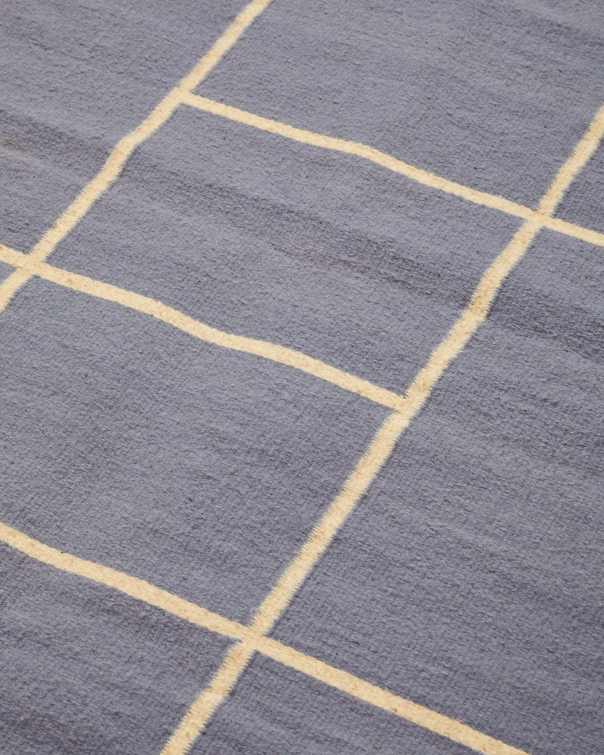 close-up detail ethically handwoven natural wool rug in lilac, naturally dyed