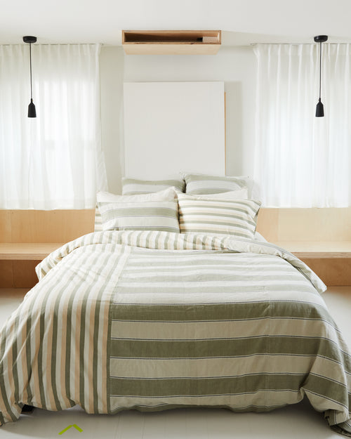 Bright bedroom with ethically handwoven oeko-tex cotton bedding designed by MINNA in sage neutral stripes