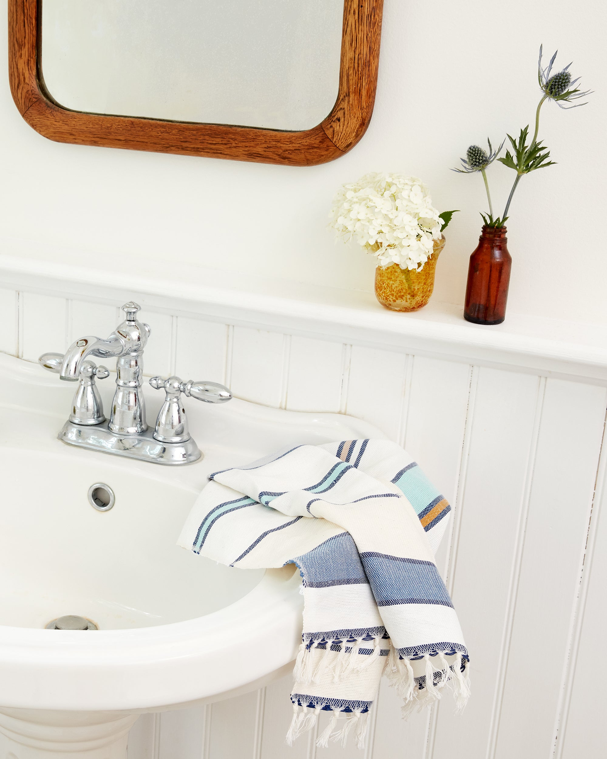 MINNA ethically handwoven cotton Lago stripe tea towel, hand towel hanging on a bathroom sink.