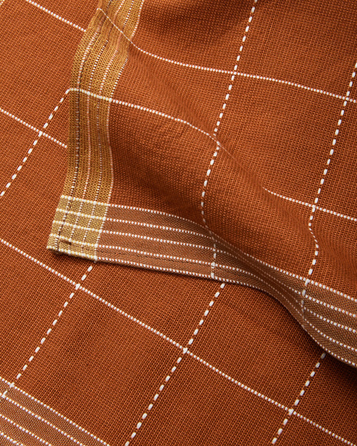 Handwoven Design of MINNA's Meridian Napkin in Robin, ethically made cotton napkin with rust and cream grid pattern.