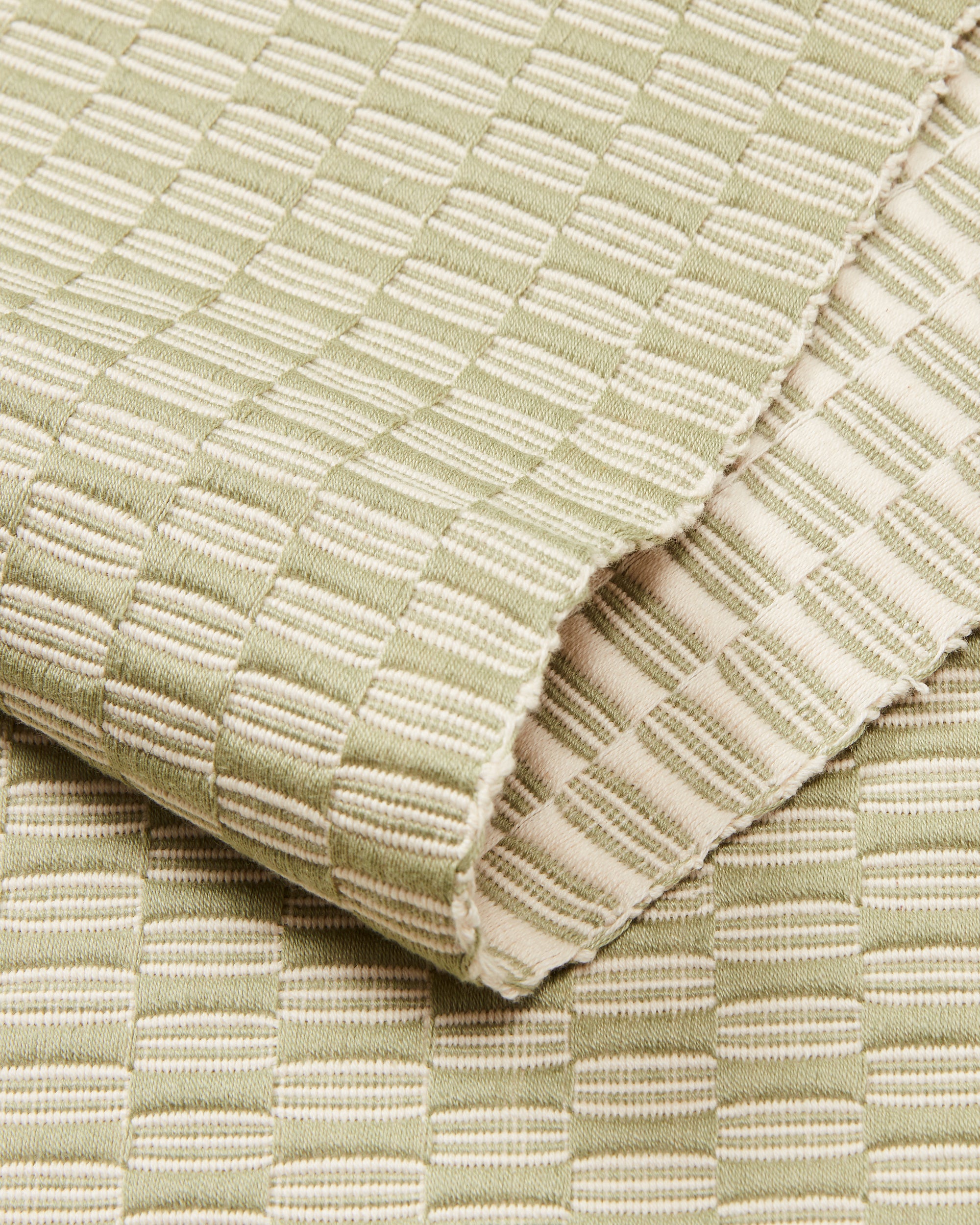 close-up detail ethically handwoven cotton table runner sage green