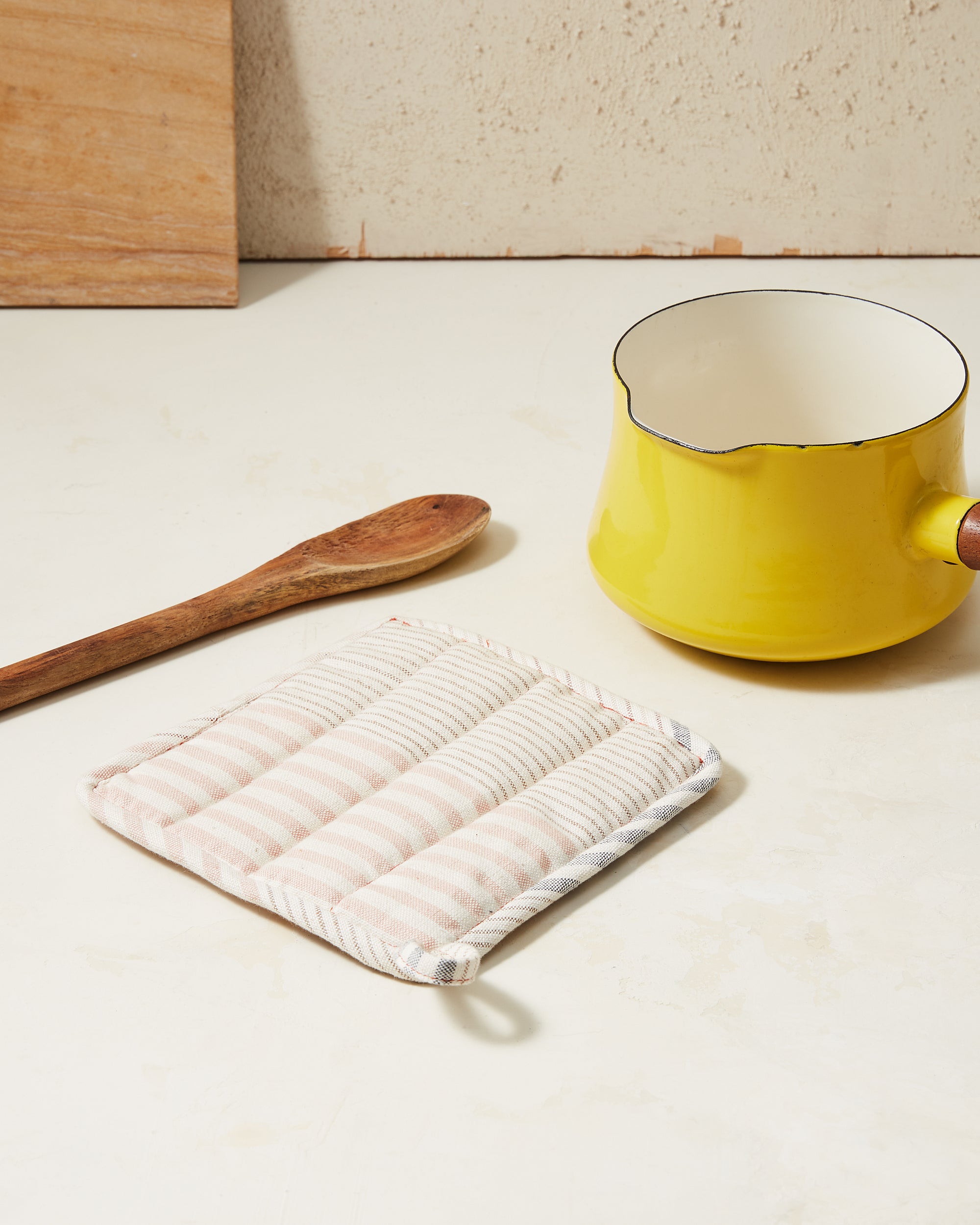 Ethically handwoven pot holder with light grey and rust, apricot colored stripes MINNA