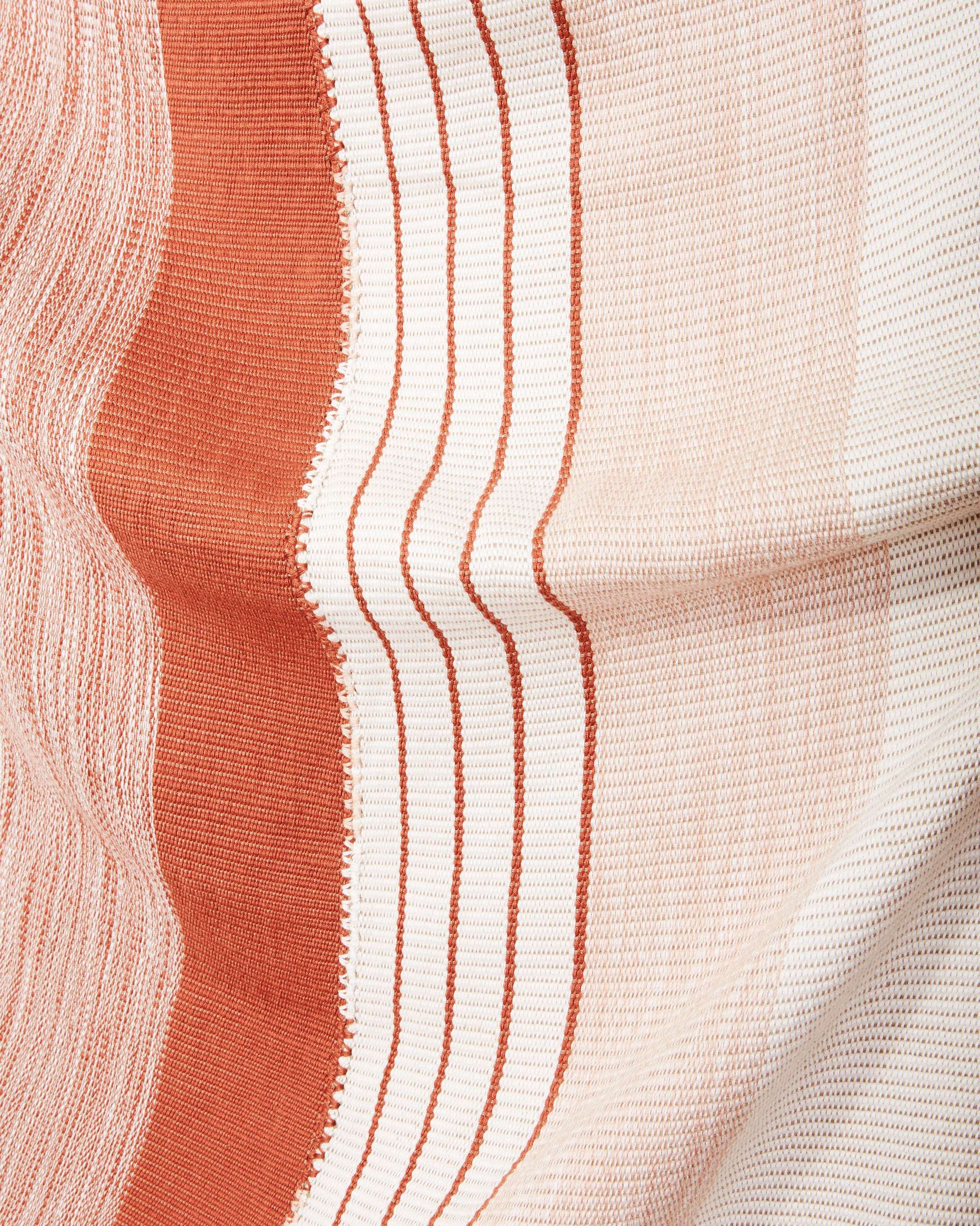 close-up of ethically handwoven oeko-tex cotton MINNA Pantelho throw striped rust, cream and white. 