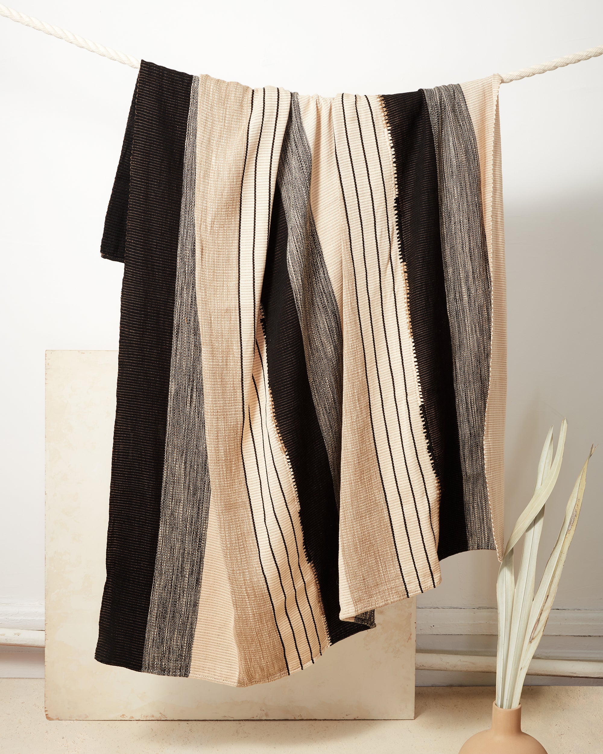 Ethically handwoven cotton throw blanket with black and beige stripes, backstrap loom