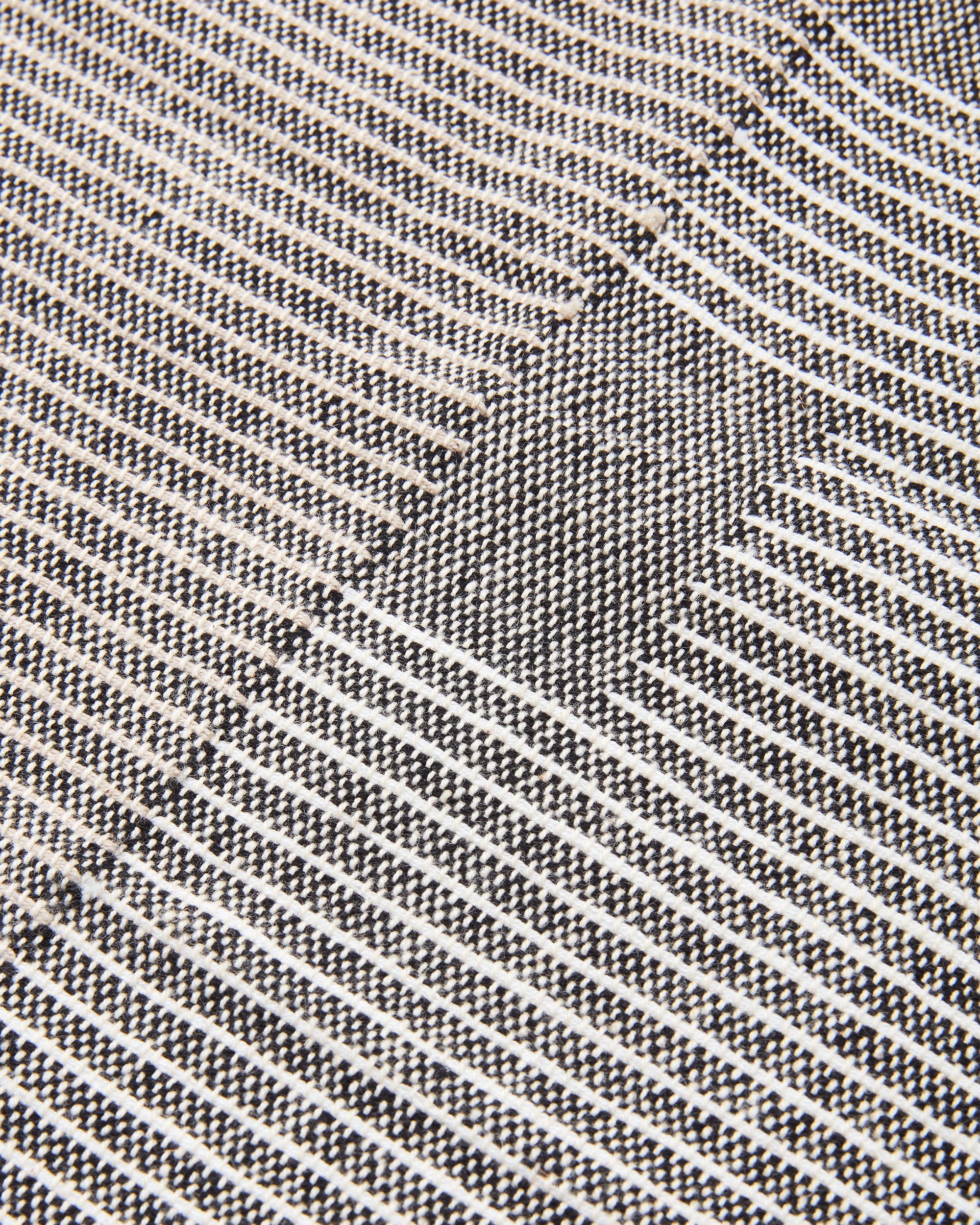 close up detail MINNA ethically handwoven Oeko Tex cotton napkin with grey background and white details
