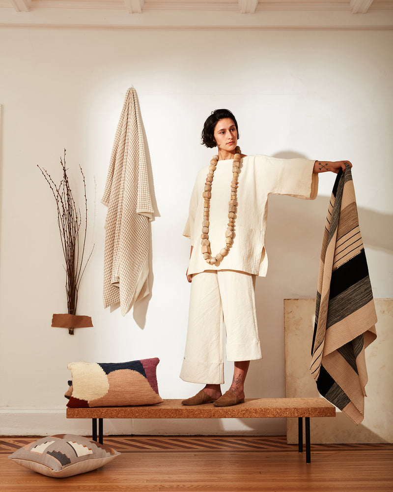 A person holding Pantelho Black and Beige handwoven throw blanket by MINNA